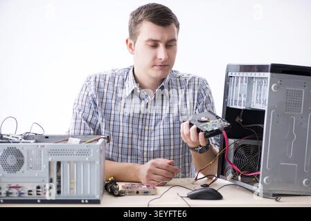 Young technician repairing computer in workshop Stock Photo