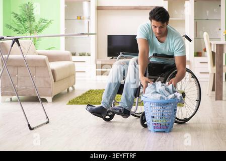 Disabled man on wheelchair doing laundry Stock Photo