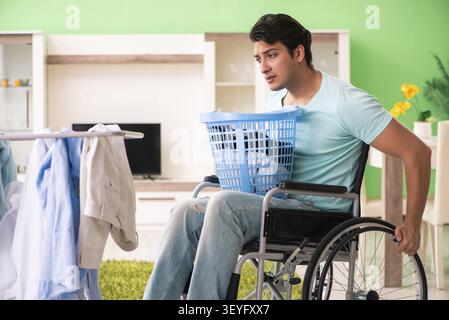 Disabled man on wheelchair doing laundry Stock Photo