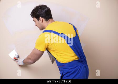 Young contractor employee applying plaster on wall Stock Photo
