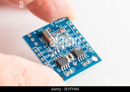 Real Time Clock Module For AVR ARM PIC Tiny RTC I2C modules memory DS1307 Clock in hand Stock Photo