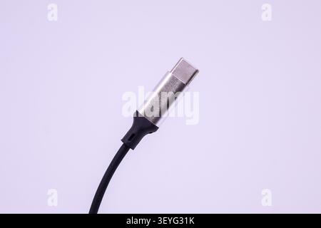 Connector end of a USB cable is shown close up on a light background. The cable is used for charging and data transmission for various devices. Stock Photo