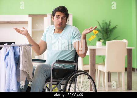 Disabled man on wheelchair doing laundry Stock Photo