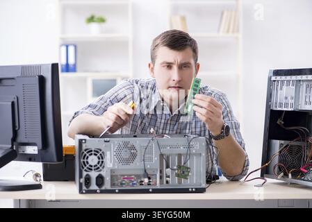 Young technician repairing computer in workshop Stock Photo
