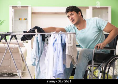 Disabled man on wheelchair doing laundry Stock Photo