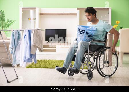 Disabled man on wheelchair doing laundry Stock Photo