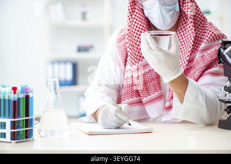 Arab doctor chemist studying new virus in lab Stock Photo