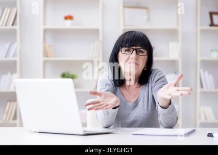 Senior woman struggling at computer Stock Photo