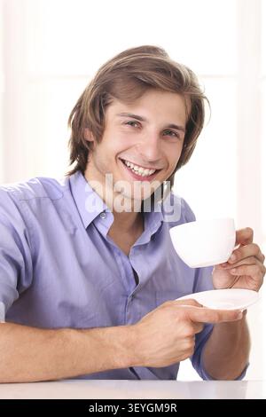 Young businessman taking a break with cup of coffee in his office Stock Photo