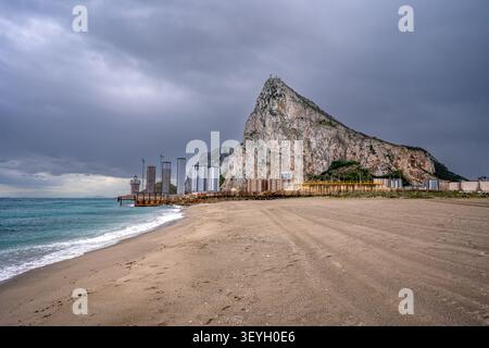 Close-up view of the sandy beach of La Línea de la Concepción. In the background stands the imposing Rock of Gibraltar and some modern residential sky Stock Photo