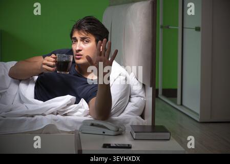 Young handsome man suffering from insomnia at home Stock Photo