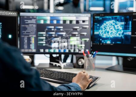 Data center programmer uses a computer to manage machine learning workloads, working with AI technology and high performance systems. Stock Photo