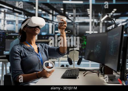 System operator uses a VR headset in a data center to manage AI systems, train neural networks, and configure hardware. Stock Photo