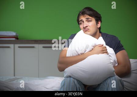 Young handsome man suffering from insomnia at home Stock Photo