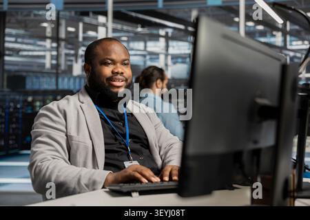 Pleased data center worker celebrates a successful server software update in a data center. Stock Photo