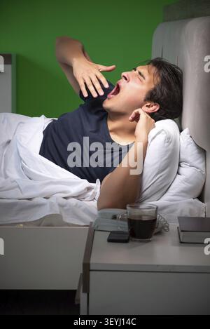Young handsome man suffering from insomnia at home Stock Photo