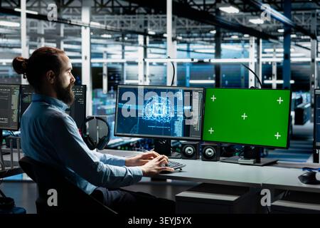 Technician tunes AI model settings on a green screen computer in a server room to improve systems. Stock Photo