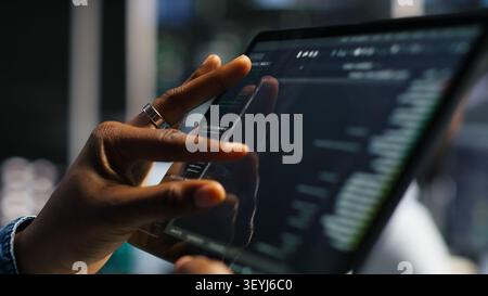 Data center programmer uses a tablet to update server software, supporting reliable infrastructure operations. Stock Photo