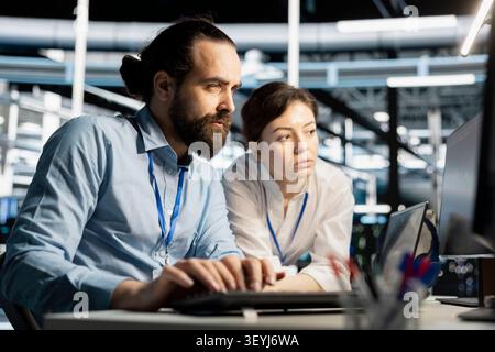 Data center colleagues collaborate on coding and AI automation scripts while reviewing server infrastructure together. Stock Photo