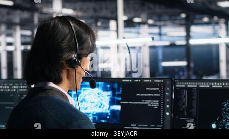System administrator uses an AI assistant in a server room to provide technical support and user troubleshooting. Stock Photo