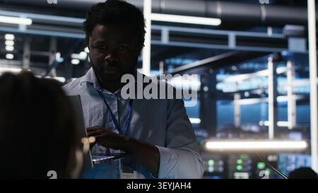 Engineer supervises node tree systems in a server farm while categorizing unstructured data. Stock Photo