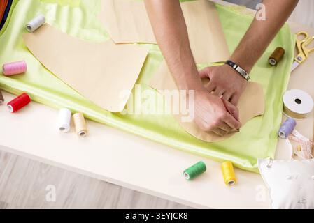 Young handsome tailor working in his workshop Stock Photo
