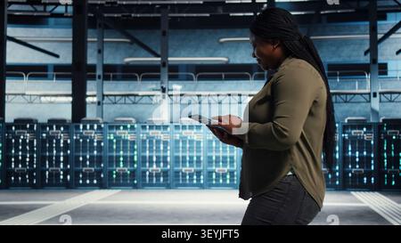 Data center technician manages software updates in a server room to keep data center systems stable. Stock Photo