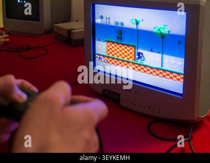 Visitor playing the classic video game Sonic the Hedgehog on a CRT television at a retro gaming exhibition. Stock Photo