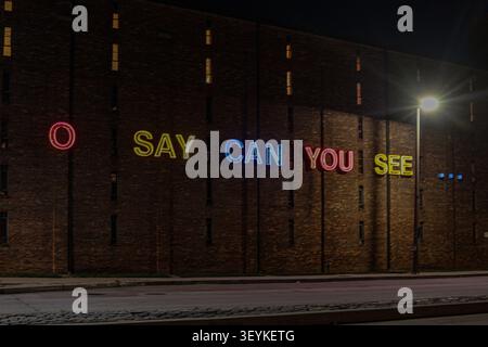 BALTIMORE, Maryland, USA.  An 11-foot glowing neon "O Say Can You See" sign illuminates the exterior of the Jim Rouse Visionary Center at the American Visionary Art Museum. Positioned near Fort McHenry, where Francis Scott Key wrote the National Anthem, the public art installation stands as a vibrant tribute to the United States ahead of the nation's 250th anniversary. 3, July, 2026. Photo Credit:  Robyn Stevens Brody/Alamy. Stock Photo