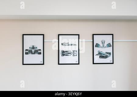 Minimalist interior wall decor featuring three framed Formula One racing car art prints in a modern room Stock Photo