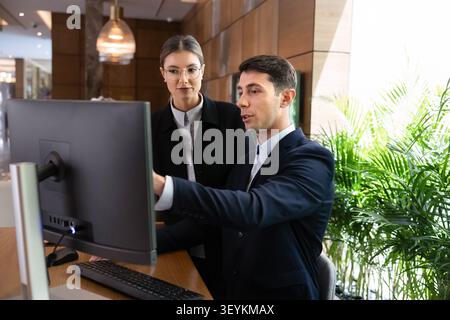 Two receptionists working together on administrative work task on computer Stock Photo