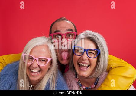 Mature friends having fun wearing colorful glasses Stock Photo