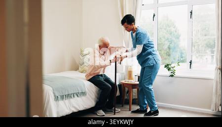 Nurse, bed or helping senior with cane in home for assisted living, healthcare or service. Female person, health worker or caregiver with man in Stock Photo