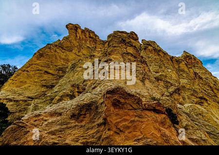 Low-angle close-up of eroded grey and tan sandstone cliff face with layered texture against blue sky, Garden of the Gods, Colorado. Stock Photo