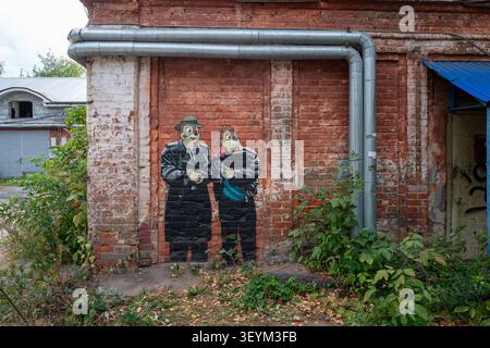 Colorful cartoon characters painted as a mural on a weathered red brick wall Stock Photo