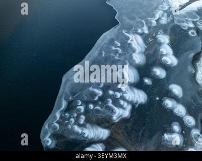 Aerial view of Albufeira da Barragem do Covao do Curral featuring intricate ice patterns and frozen textures on the water surface in Sao Romao, Distri Stock Photo