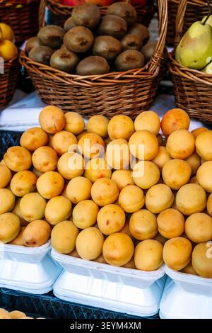 Fresh harvest of golden apricots. View of a large, mounded pile of freshly harvested, sun-ripened apricots in a container, Stock Photo