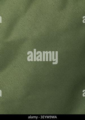 Dense synthetic olive khaki fabric texture with fine plain weave and soft folds, close-up background Stock Photo