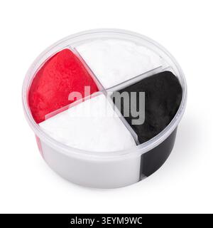 Open round container of air-dry play dough in four sections of red, white, and black colors, isolated on white background, genuine photo Stock Photo