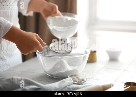 Woman preparing traditional cinnamon rolls in kitchen Stock Photo