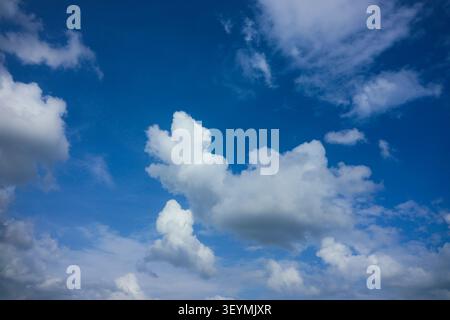 Cinematic Blue Sky with Large Billowing Cloud Formations.A dramatic and high-contrast sky featuring large, puffy clouds. Stock Photo