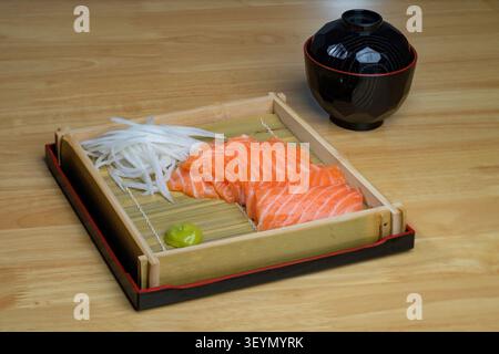 a set of japaness style sliced samon sashimi on bamboo plate with japanese soup in black bowl on wooden table Stock Photo