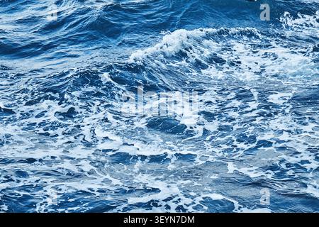 deep blue sea surface with wave by the heavy wind with many white bubble Stock Photo