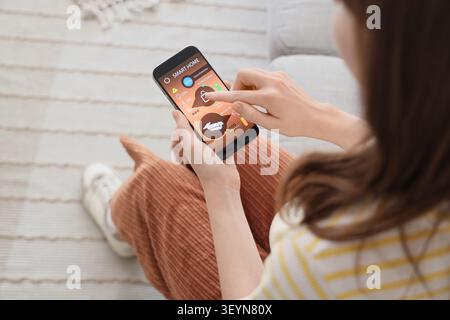 Woman using smartphone smart home security app Stock Photo