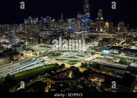 illuminated chicago skyline at night from aerial perspective with dynamic and vibrant urban environment and highway interchanges featuring high-rise Stock Photo