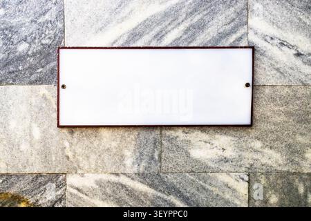 blank white sign on wall made of marble slabs Stock Photo