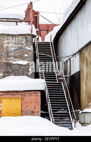 snow-covered stairs in courtyard of idle old Demidov metallurgical plant in Nizhny Tagil city Stock Photo