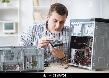 Young technician repairing computer in workshop Stock Photo