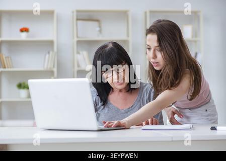 Daughter explaining to mom how to use computer Stock Photo