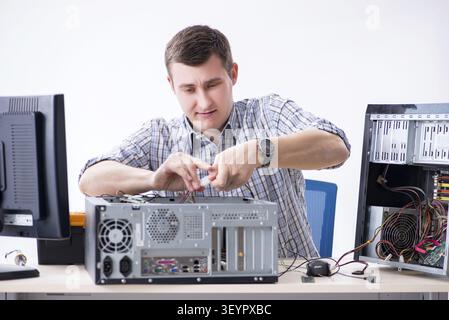 Young technician repairing computer in workshop Stock Photo